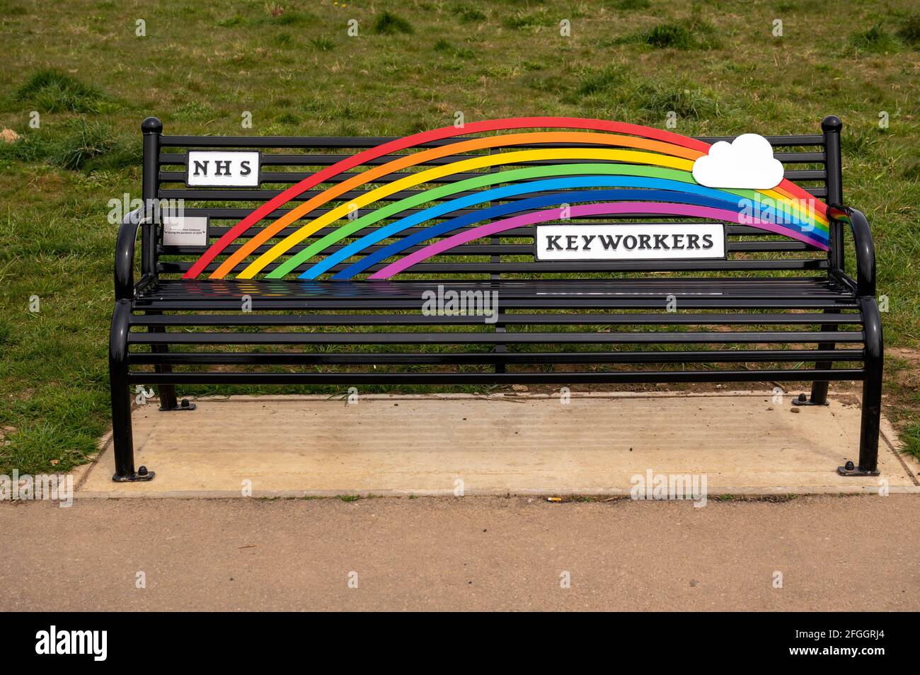 A rainbow colored park bench dedicated to the NHS and keyworkers during the pandemic covid 19 from the community of Costessey Norwich Norfolk England Stock Photo
