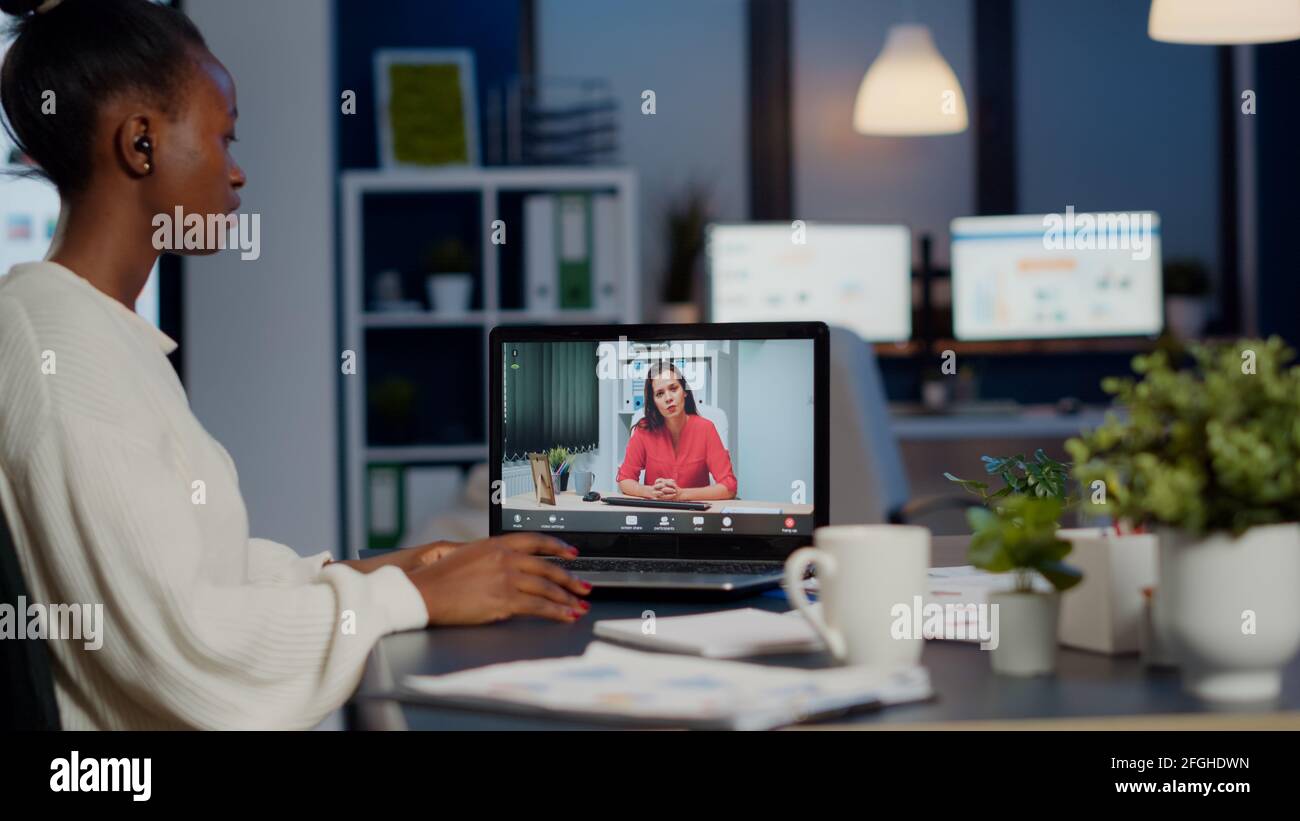 African Businesswoman Discussing With Remotely Woman Partner Online Sitting In Front Of Laptop Working In Start Up Office Talking On Video Call During Virtual Meeting At Midnight Using Headphone Stock Photo Alamy