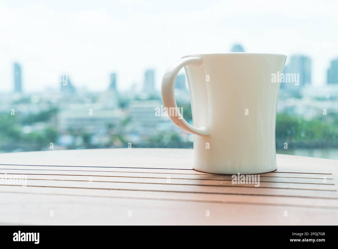 cup of coffee on table with skyline city background Stock Photo