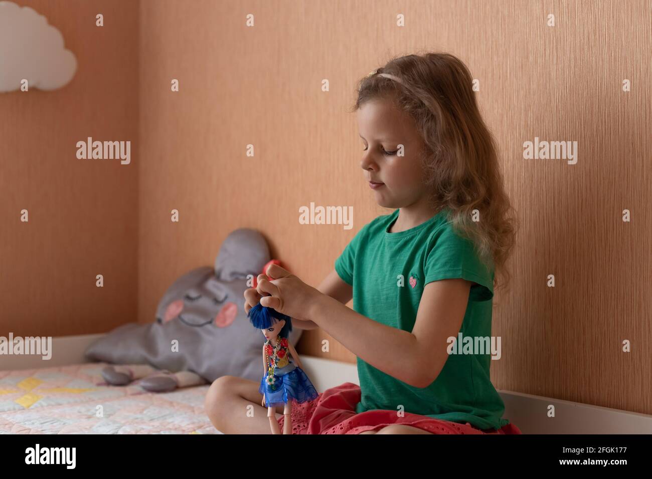 Cute little girl playing with doll Stock Photo - Alamy