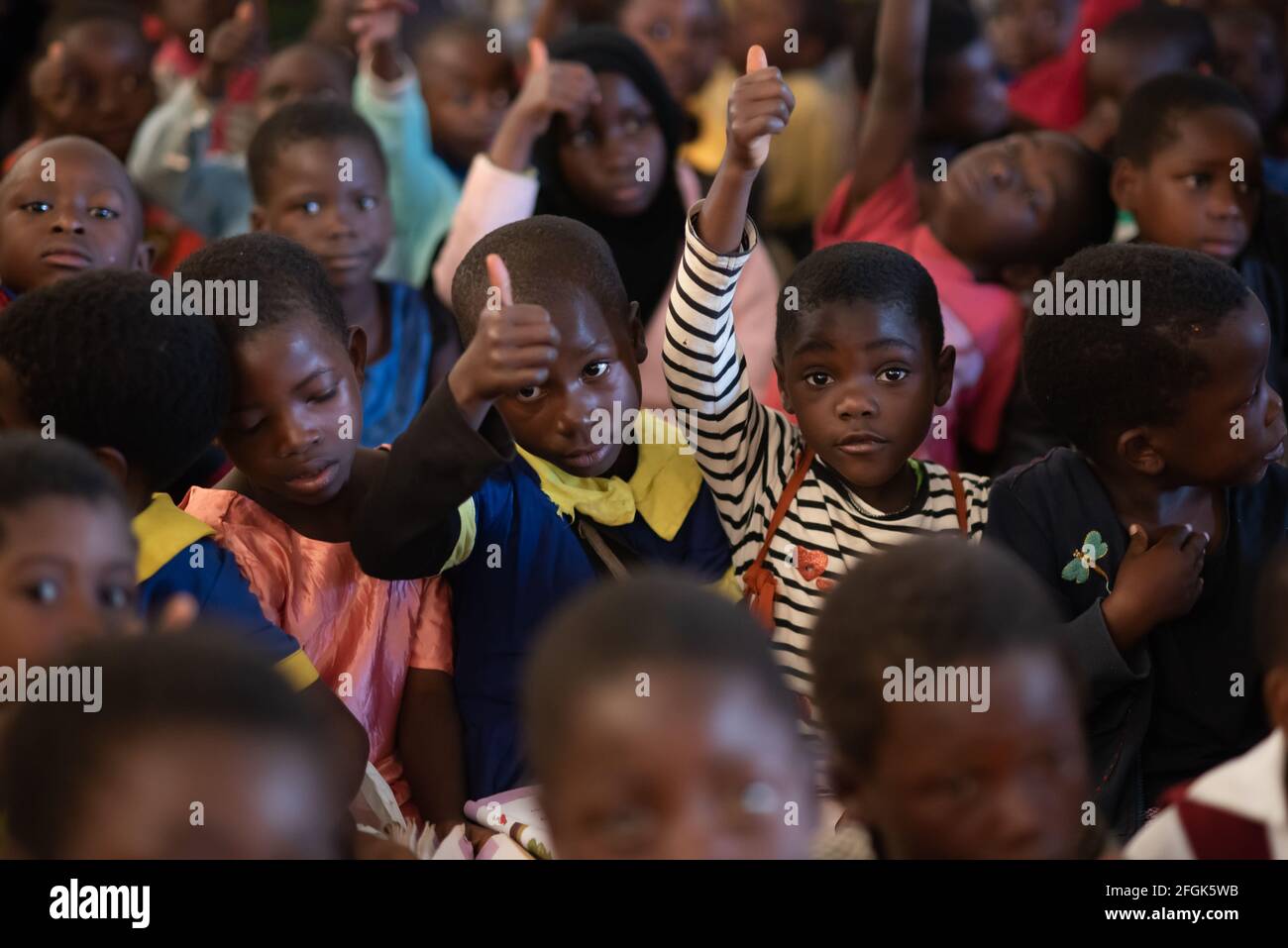 Mzuzu, Malawi. 30-05-2018. Afro-descendent children attending classes at a rural school in Malawi showing a thumps up toi their teacher. Stock Photo
