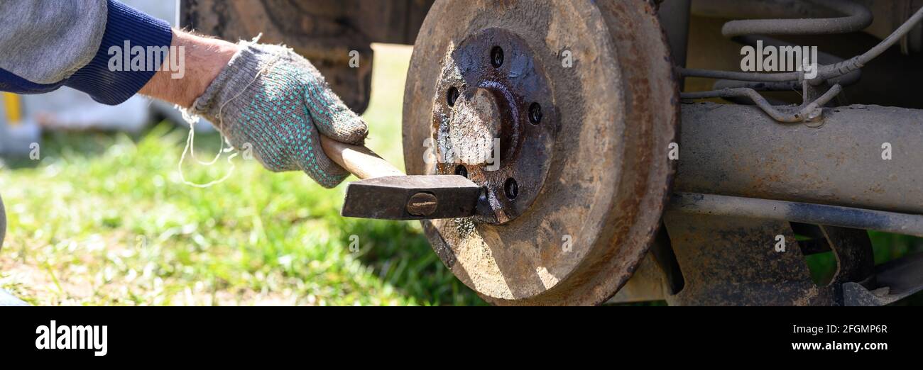 men's gloved hands repair of car drum brake himself. disassembles a