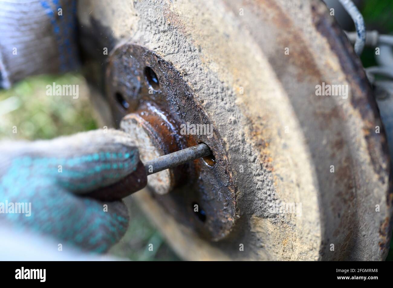 men's gloved hands repair of car drum brake himself. disassembles a