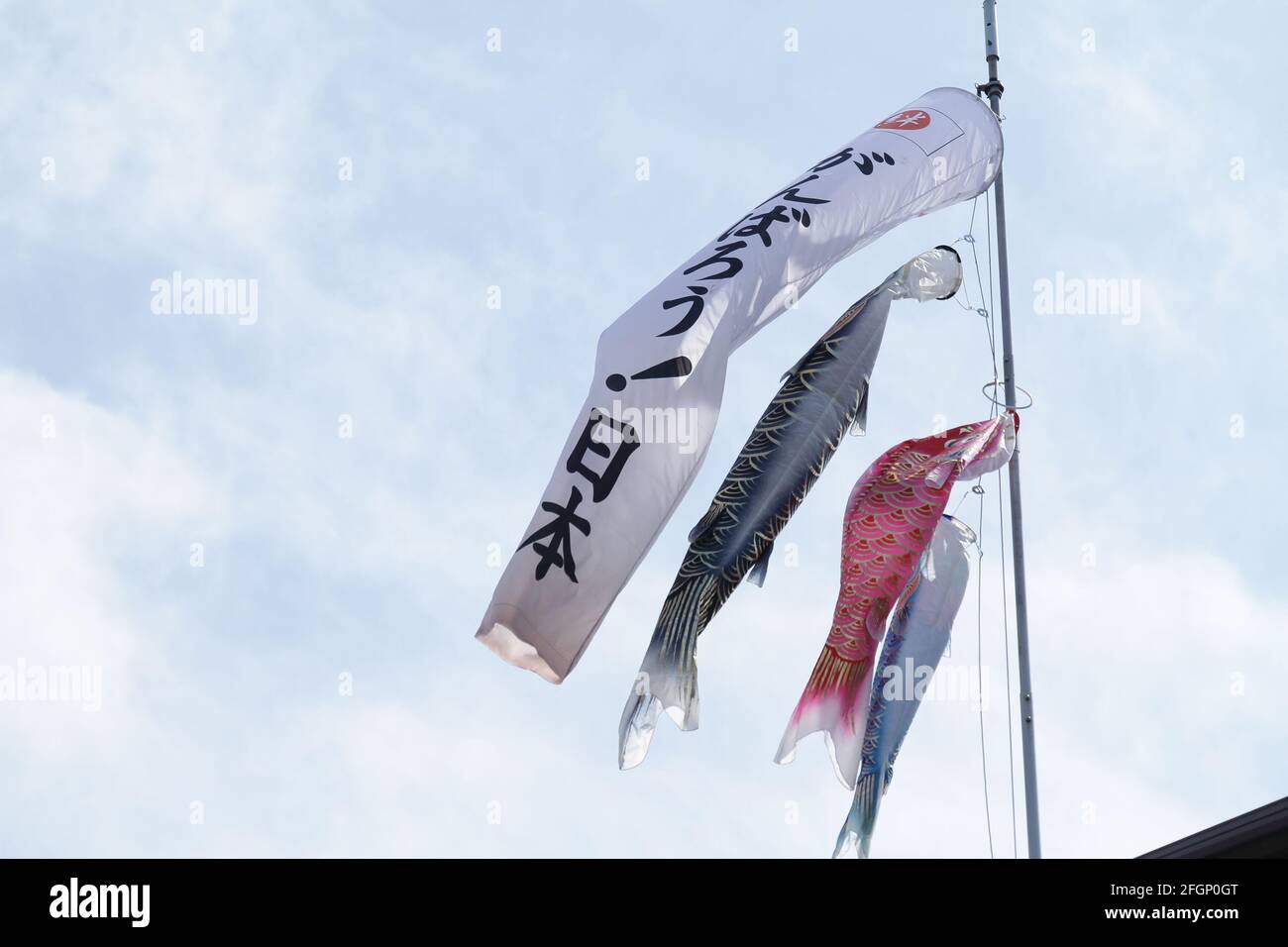iida, Nagano, Japan, 25-04-2021 , Carp Coi flags, waving in the wind together with a 'gambaro' message for japan. 'gambarou' meaning is ”Let's do our Stock Photo