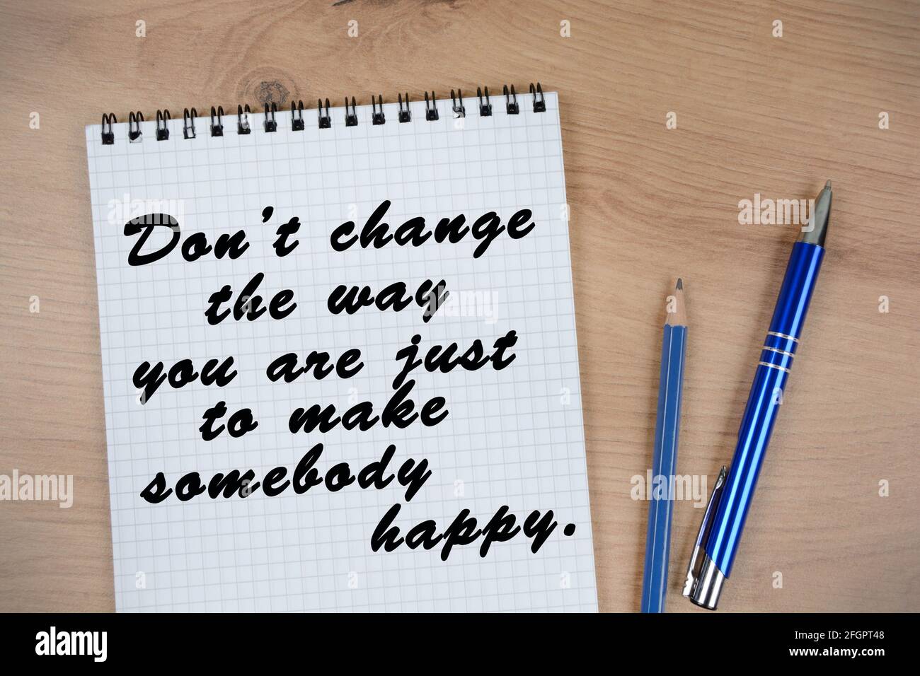 Don't change the way you are, just to make somebody happy words on notebook. Inspirational quote Stock Photo