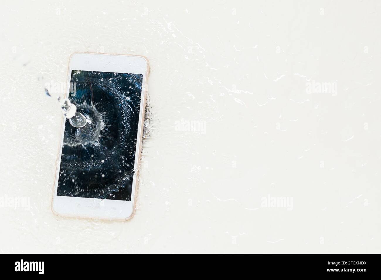 Phone dropped into the water. Telephone and water drops Stock Photo