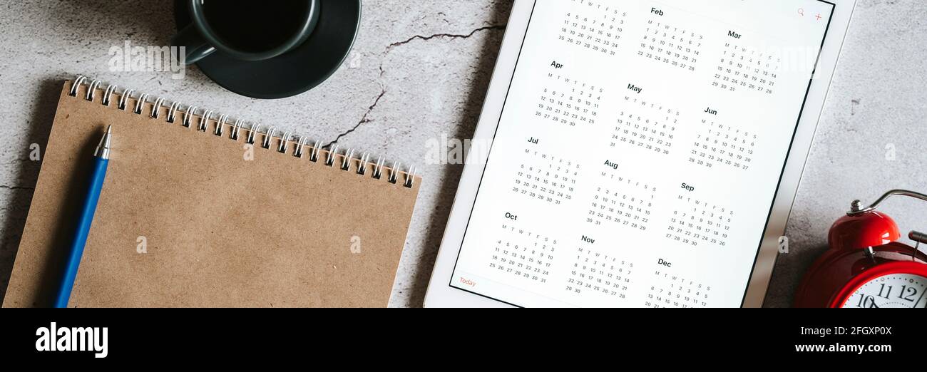 https://c8.alamy.com/comp/2FGXP0X/a-tablet-with-an-open-calendar-for-2021-year-a-red-alarm-clock-a-cup-of-coffee-and-a-craft-paper-notebook-on-a-gray-concrete-background-banner-2FGXP0X.jpg