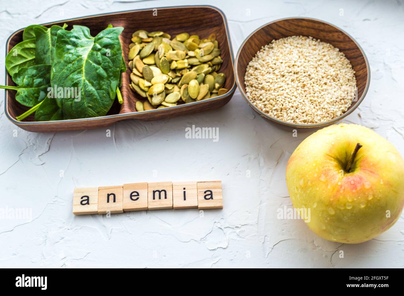 Spinach, pumpkin seeds, sesame, apple on a white background. Anemia concept. Closeup Stock