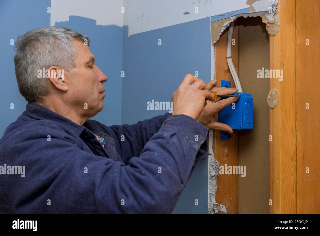 Electrical is installing new junction box to the beams Stock Photo