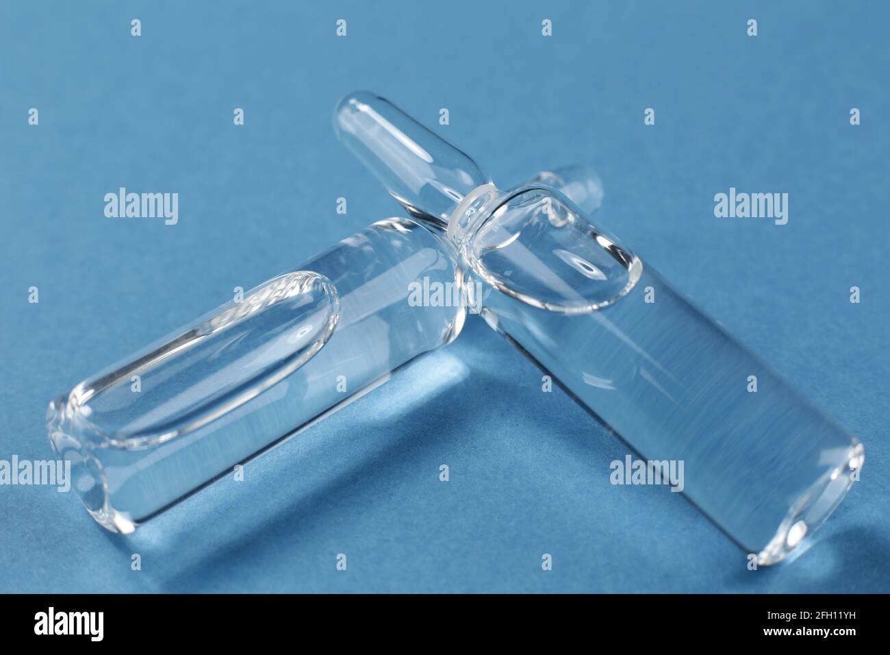 Glass vials with medical vaccine on blue background Stock Photo - Alamy