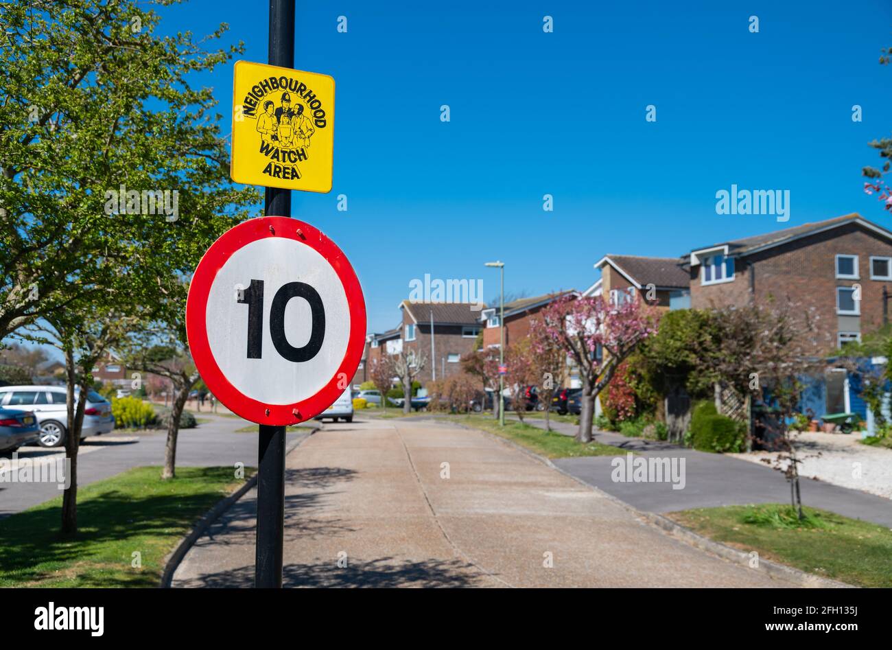 10MPH speed limit sign and Neighbourhood Watch Area sign at the entrance to a residential road or street in England, UK. Stock Photo