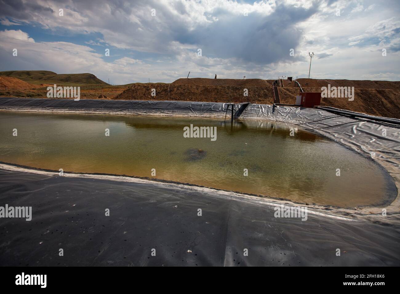 Almaty region, Kazakhstan: Extraction of gold ore. Mining and processing plant. Pond for chemical refining by sodium cyanide. Stock Photo
