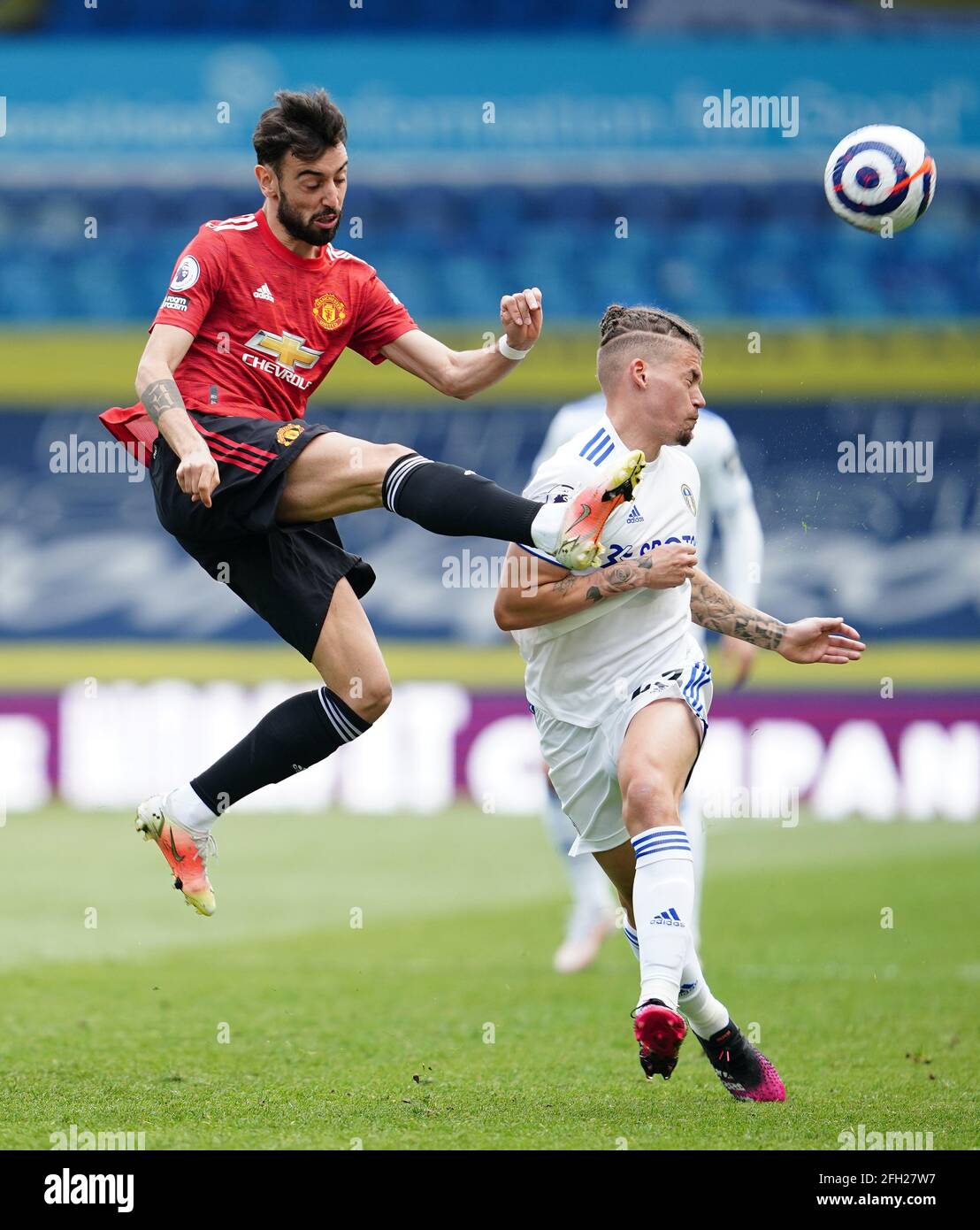 Manchester United's Bruno Fernandes (left) and Leeds United's Ezgjan Alioski battle for the ball during the Premier League match at Elland Road, Leeds. Picture date: Sunday April 25, 2021. Stock Photo