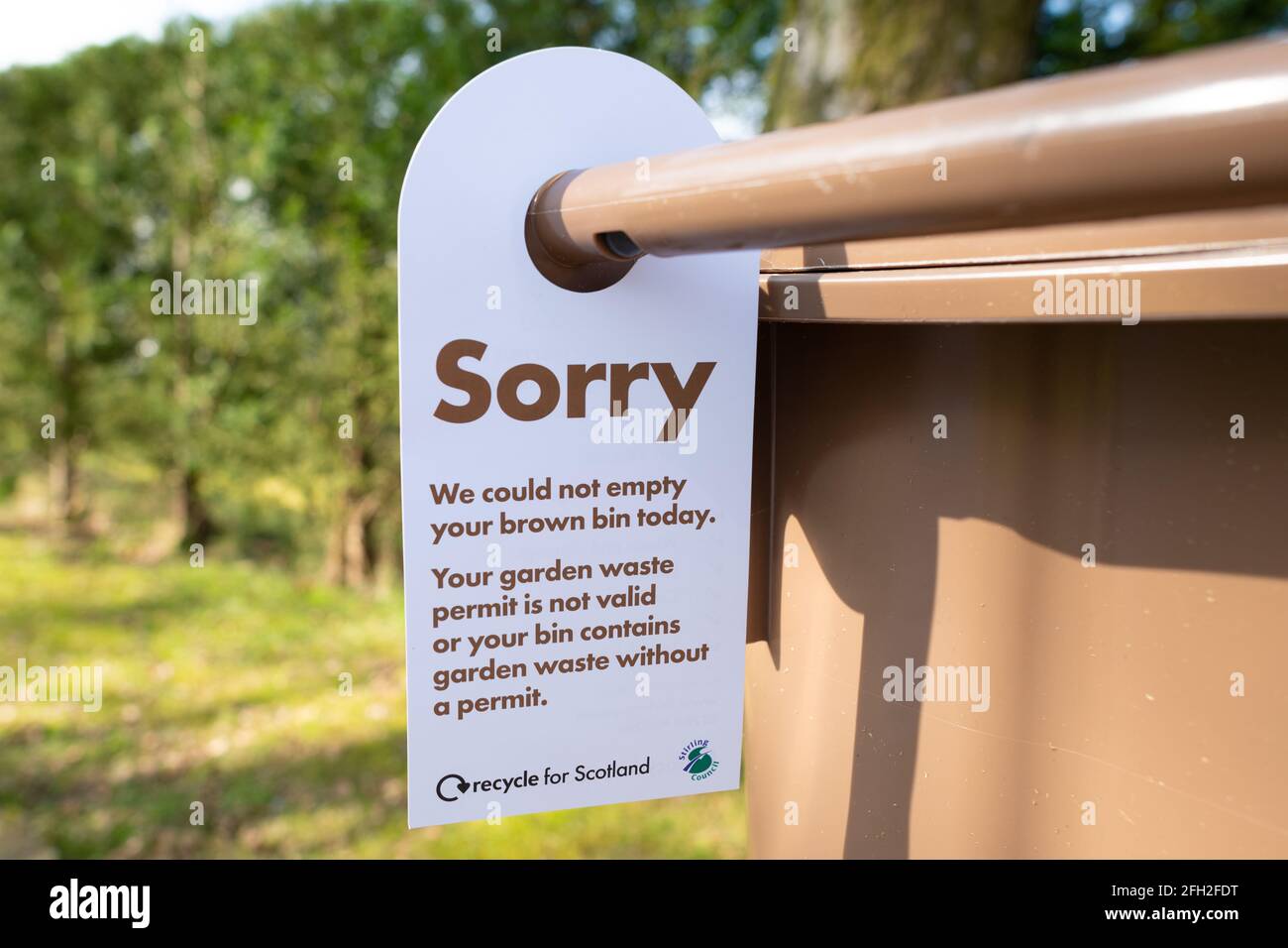 Garden Waste permit - Sorry we could not empty your brown bin today notice on brown bin - Stirling, Scotland, UK Stock Photo