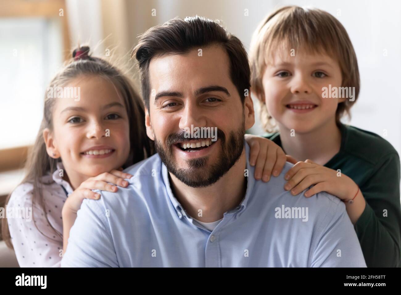 Headshot portrait of happy dad and kids hugging Stock Photo