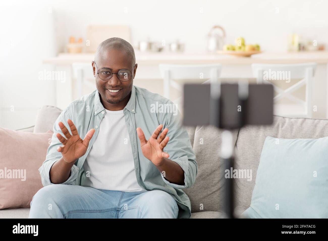 Video recording for modern blog as a remote work or hobby. Mature black man  looking in smartphone camera on tripod Stock Photo - Alamy