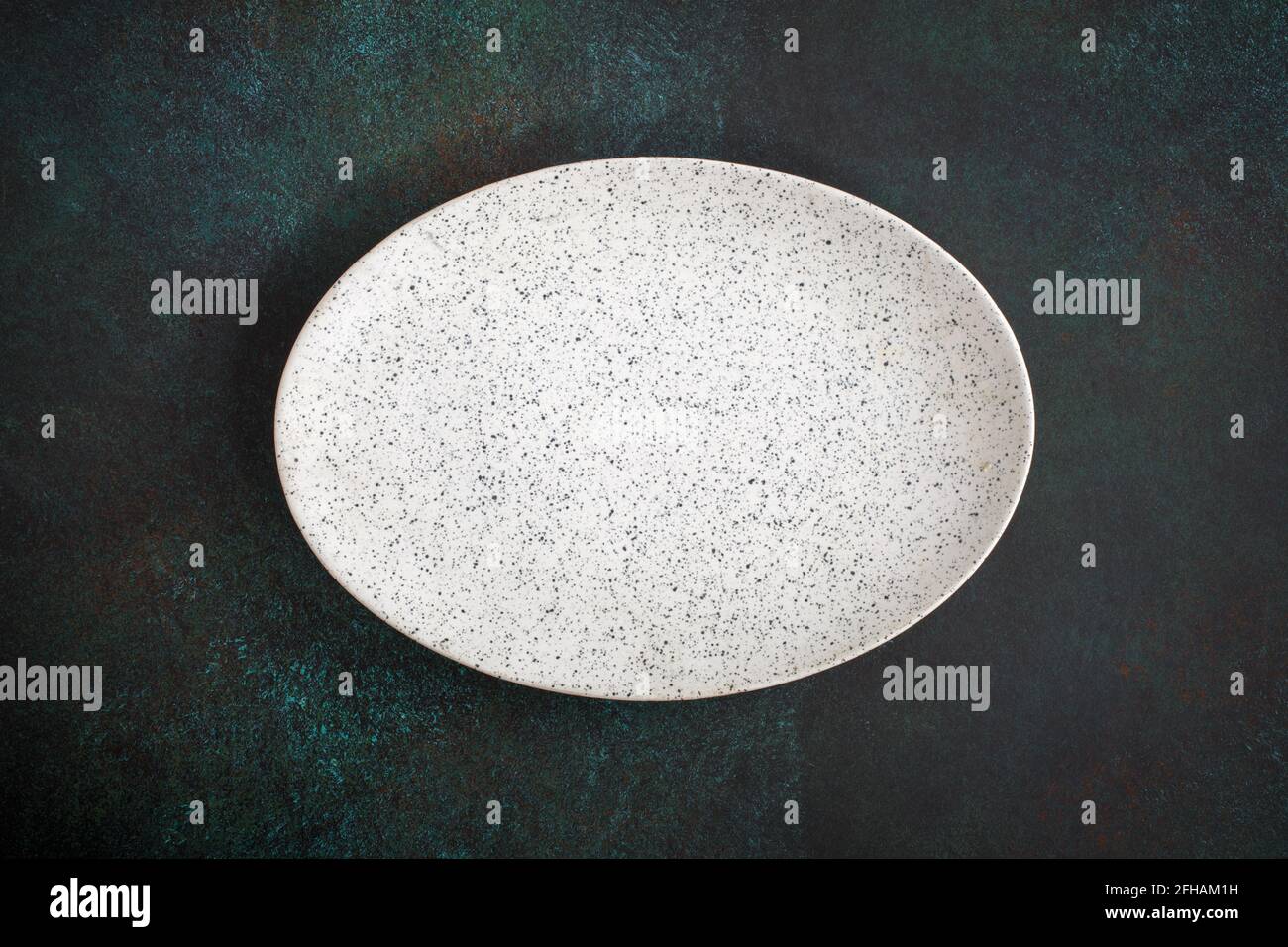 Empty oval plate on dark concrete background. Top view, with copy space Stock Photo