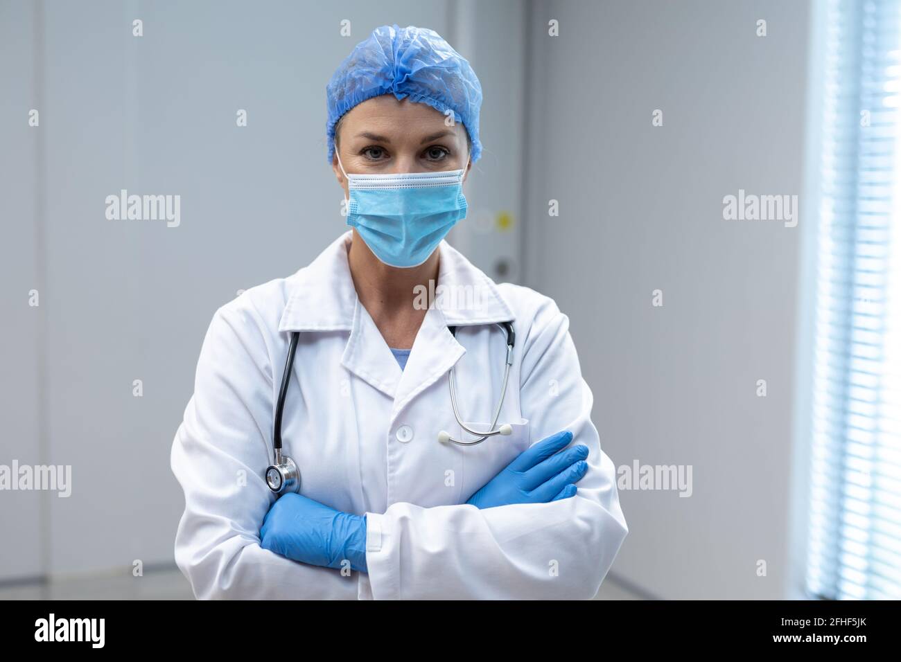 Portrait of caucasian female doctor wearing mask and latex gloves Stock Photo