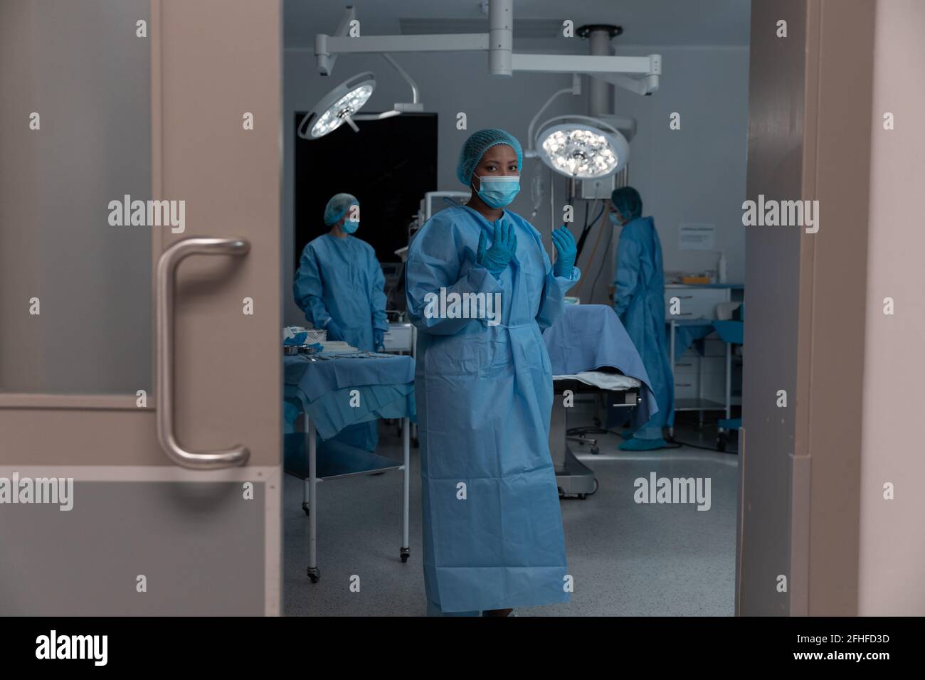 Diverse group of male and female doctors in operating theatre wearing