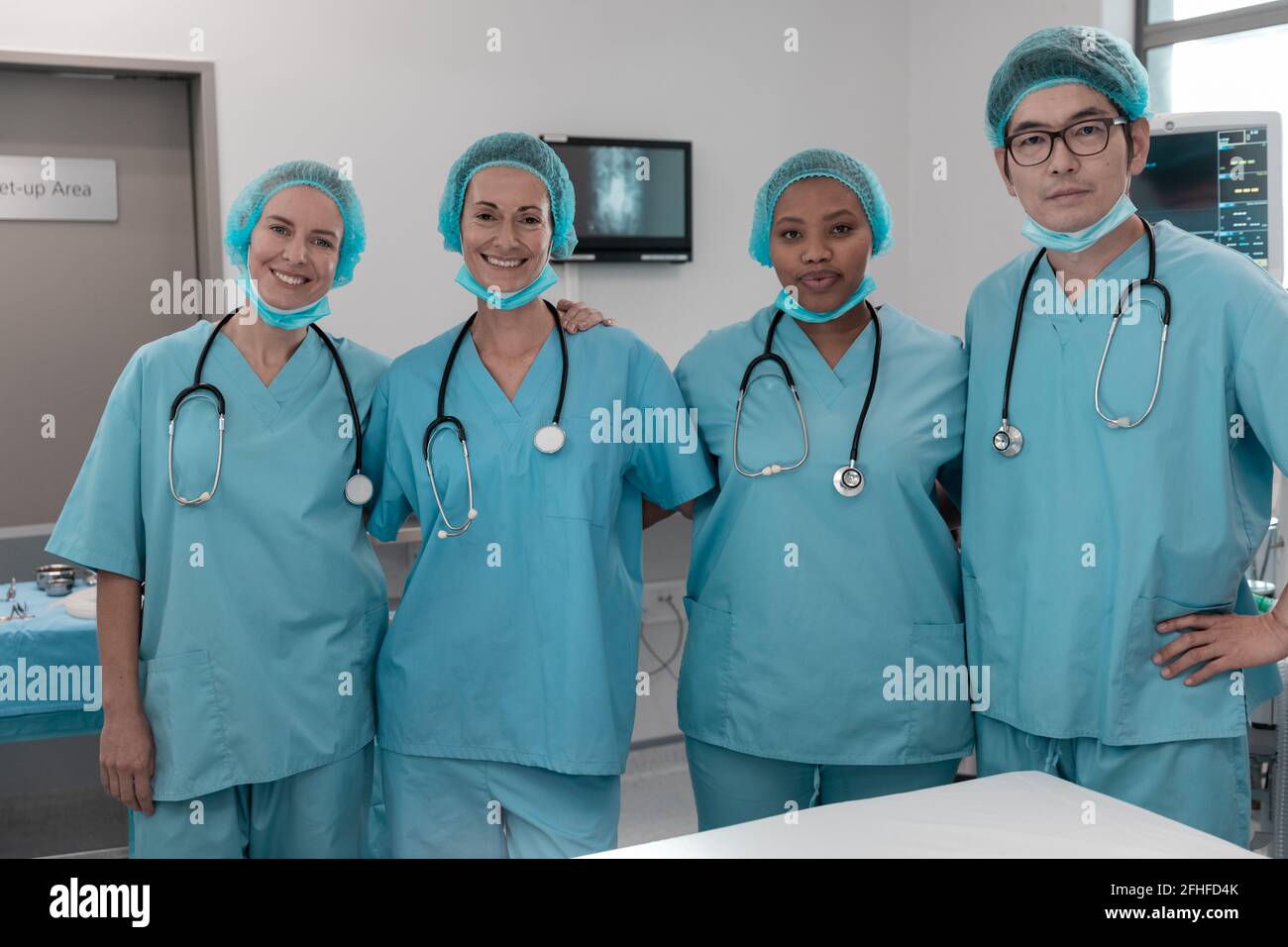 Portrait of diverse group of male and female doctors standing in operating theatre Stock Photo
