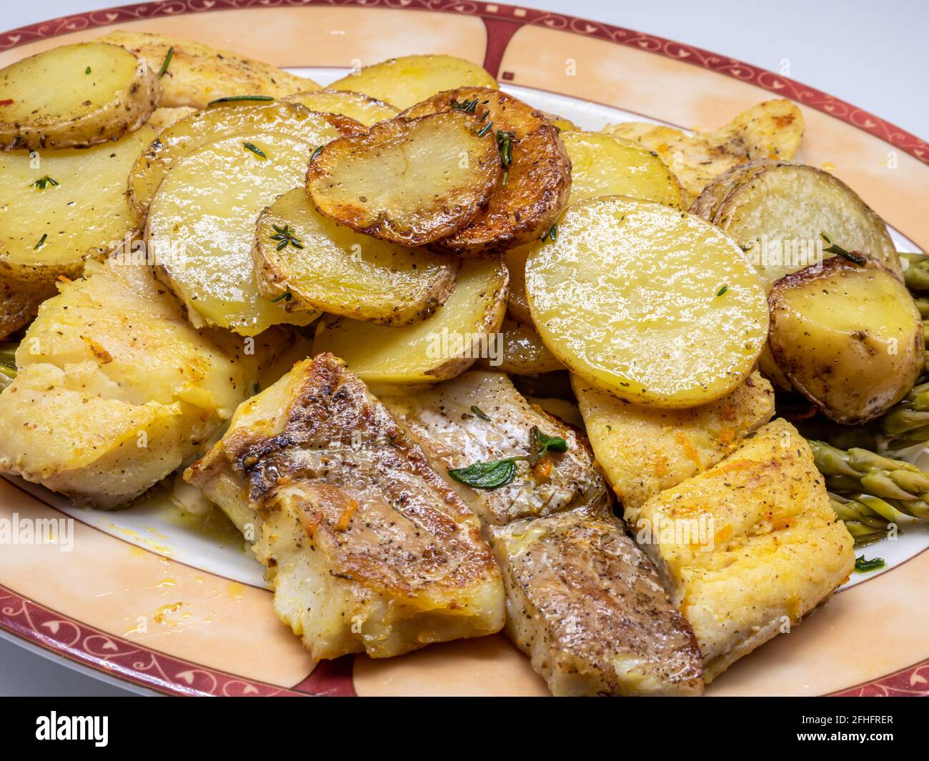Fresh cod with fried potatoes and asparagus Stock Photo Alamy