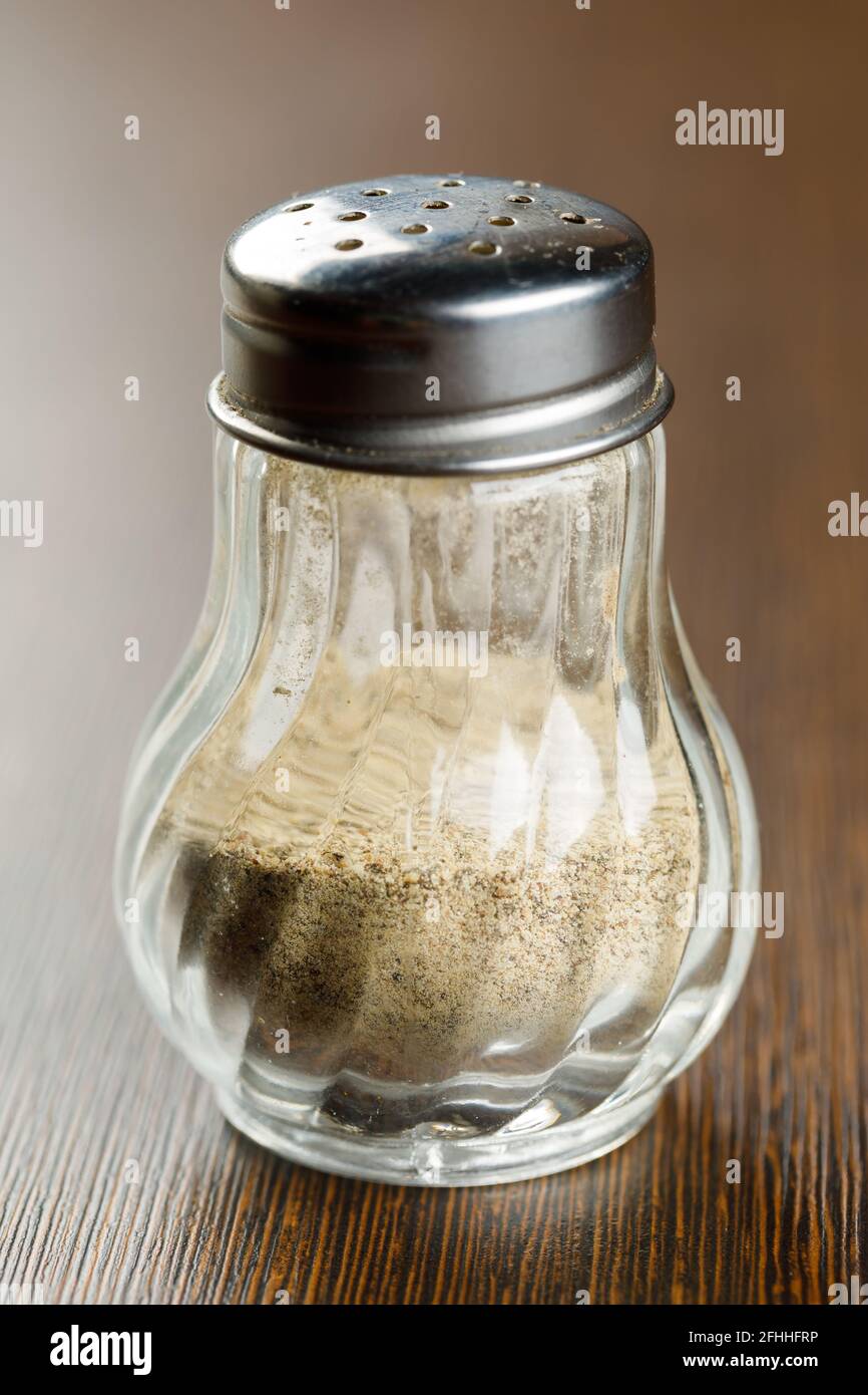 Pepper shaker of ground paprika pepper on a wooden background Stock Photo -  Alamy