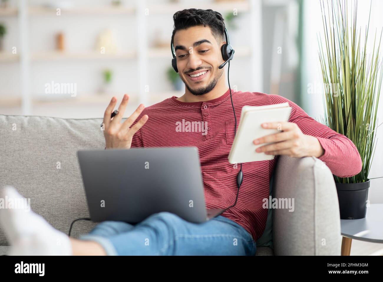 Positive arab guy attending online training from home Stock Photo