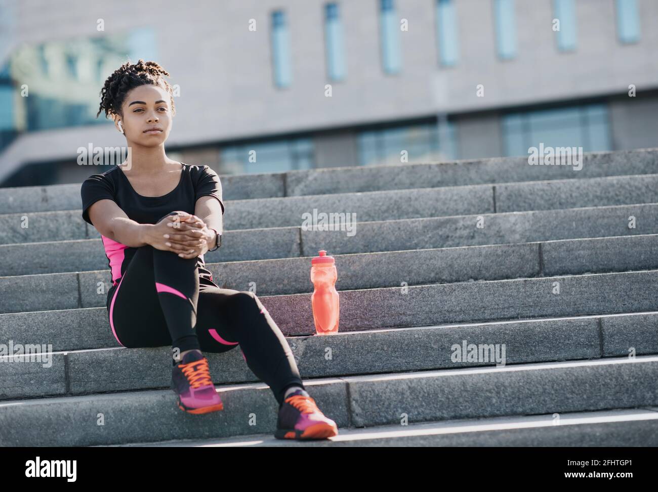 Urban workout, health care and relaxation after running, modern training with gadgets Stock Photo