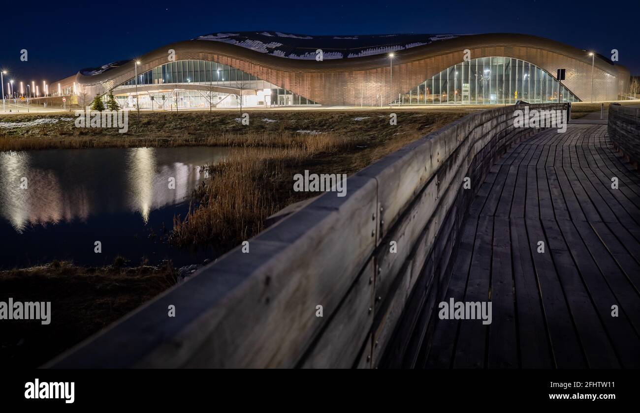 Calgary Alberta Canada, April 22 2021: Modern architecture of the Royal Oak YMCA along a wooden boardwalk over a natural pond during the evening. Stock Photo