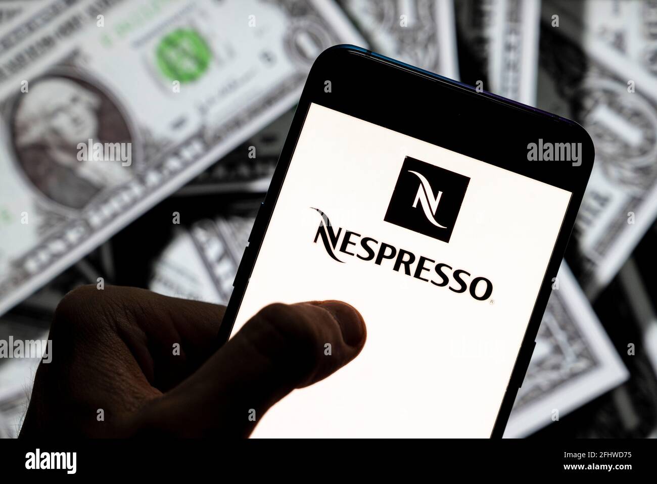 China. 21st Apr, 2021. In this photo illustration, a Nespresso logo seen displayed on a smartphone with USD (United States dollar) currency in the background. Credit: Budrul Chukrut/SOPA Images/ZUMA Wire/Alamy Live News Stock Photo