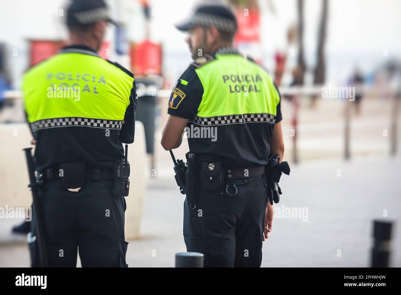 Spanish police squad formation back view with "Local Police" logo emblem on  uniform maintain public order in the streets of Alicante, Spain Stock Photo  - Alamy