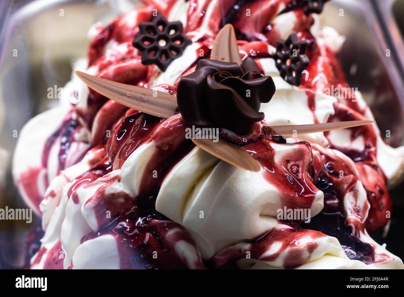 https://c8.alamy.com/comp/2FJ0A4R/tub-of-cream-ice-cream-and-strawberry-syrup-with-chocolate-flowers-in-artistic-way-in-an-italian-ice-cream-shop-to-refresh-on-a-hot-day-2FJ0A4R.jpg