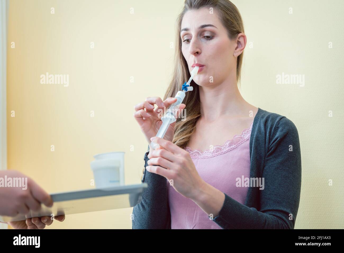 Woman in hospital breathing in tube to test for respiratory disease Stock Photo