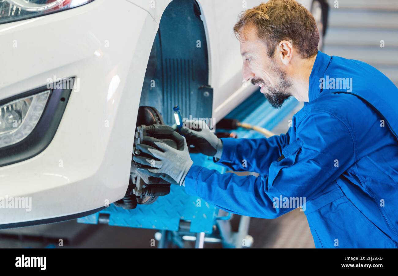 Auto mechanic servicing car in the workshop Stock Photo