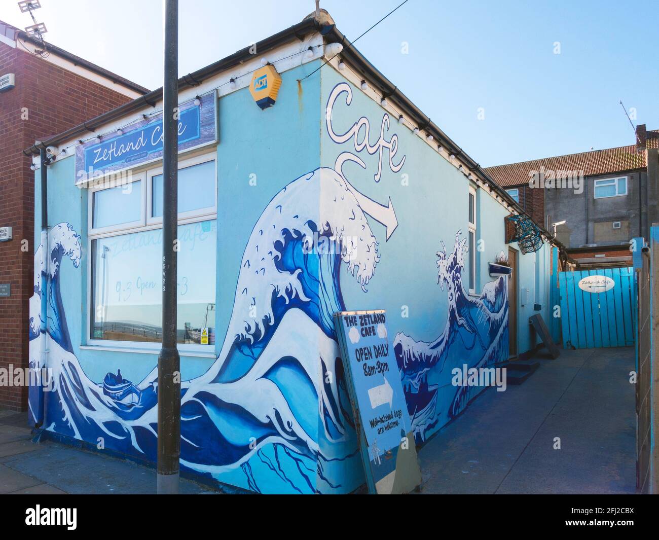 Zetland Café on the seafront at Redcar decorated with blue painted waves and local fishing boats Stock Photo