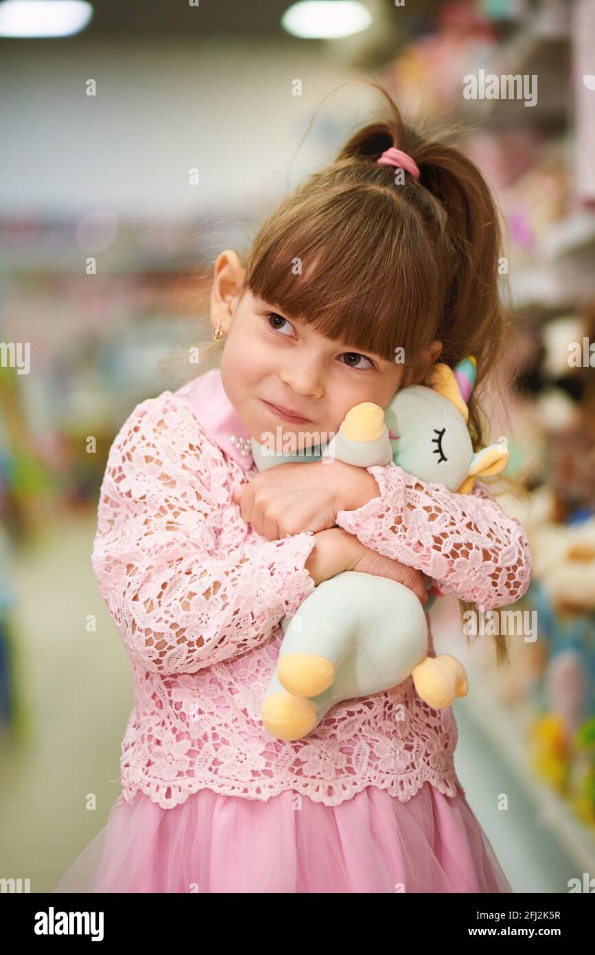 Little happy girl with toys in a children's store Stock Photo Alamy