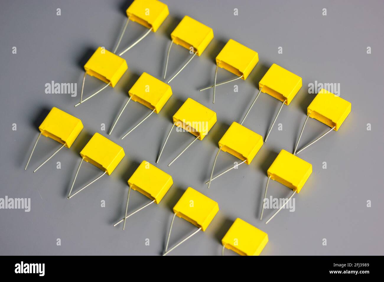 Yellow film capacitors on gray background top view. Electronic radio components Stock Photo Alamy