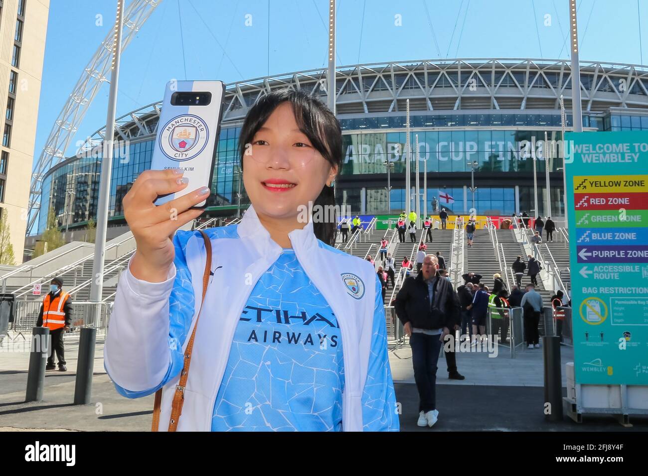 Wembley Stadium, Wembley Park, UK. 25th April 2021.Manchester City fans outside Wembley Stadium ahead of the Carabao Cup Final match between Manchester City and Tottenham Hoptspur.  8,000 local residents, NHS Staff and fans are expected to attend the match, the largest number of spectators attending a sporting event in a UK stadium for over a year.  Covid-19 Lateral Flow testing will take before and after the match and data gathered will be used to plan how all events can take place following lockdown. Amanda Rose/Alamy Live News Stock Photo