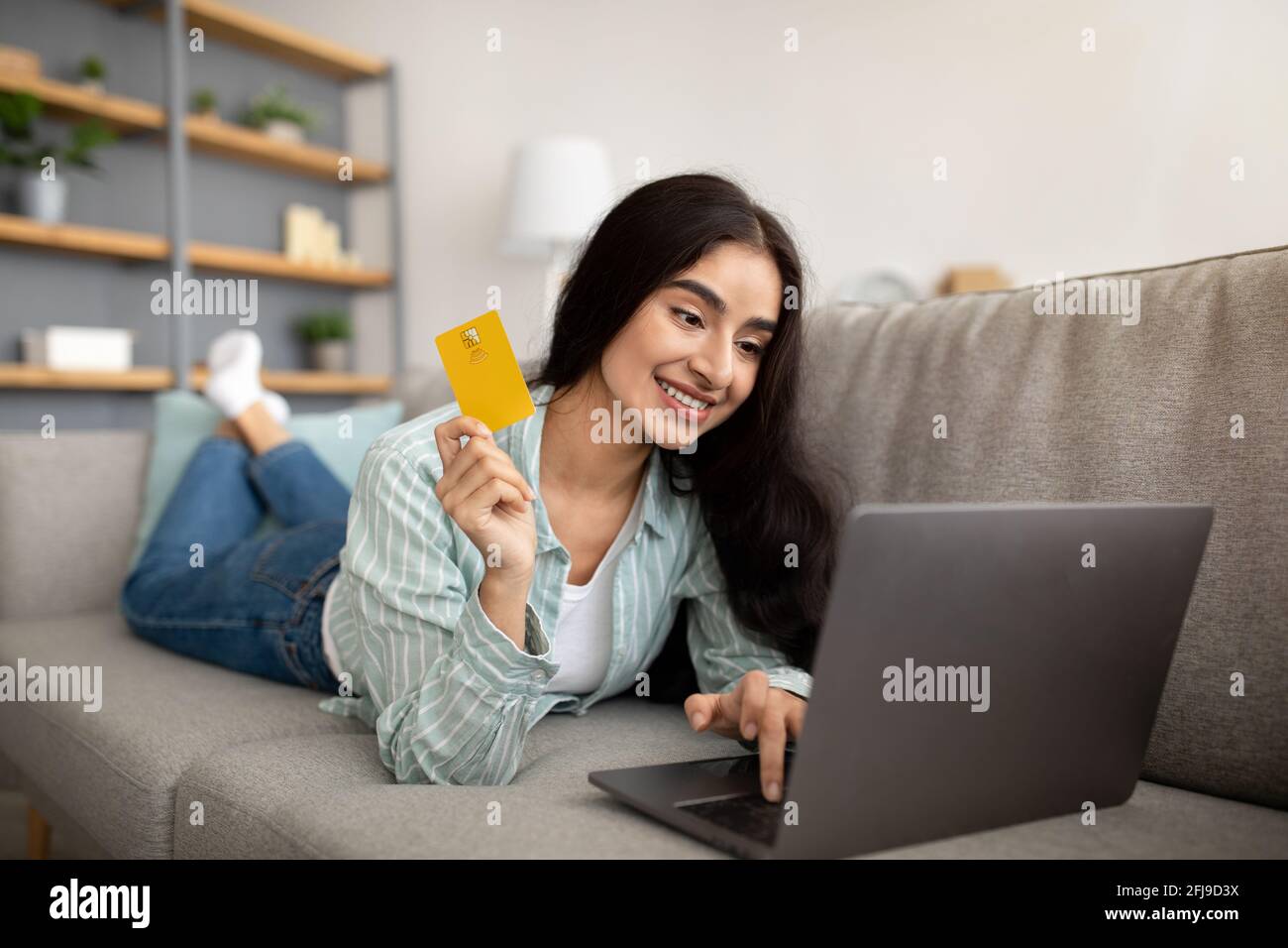 Online shopping. Beautiful Indian lady with laptop and credit card