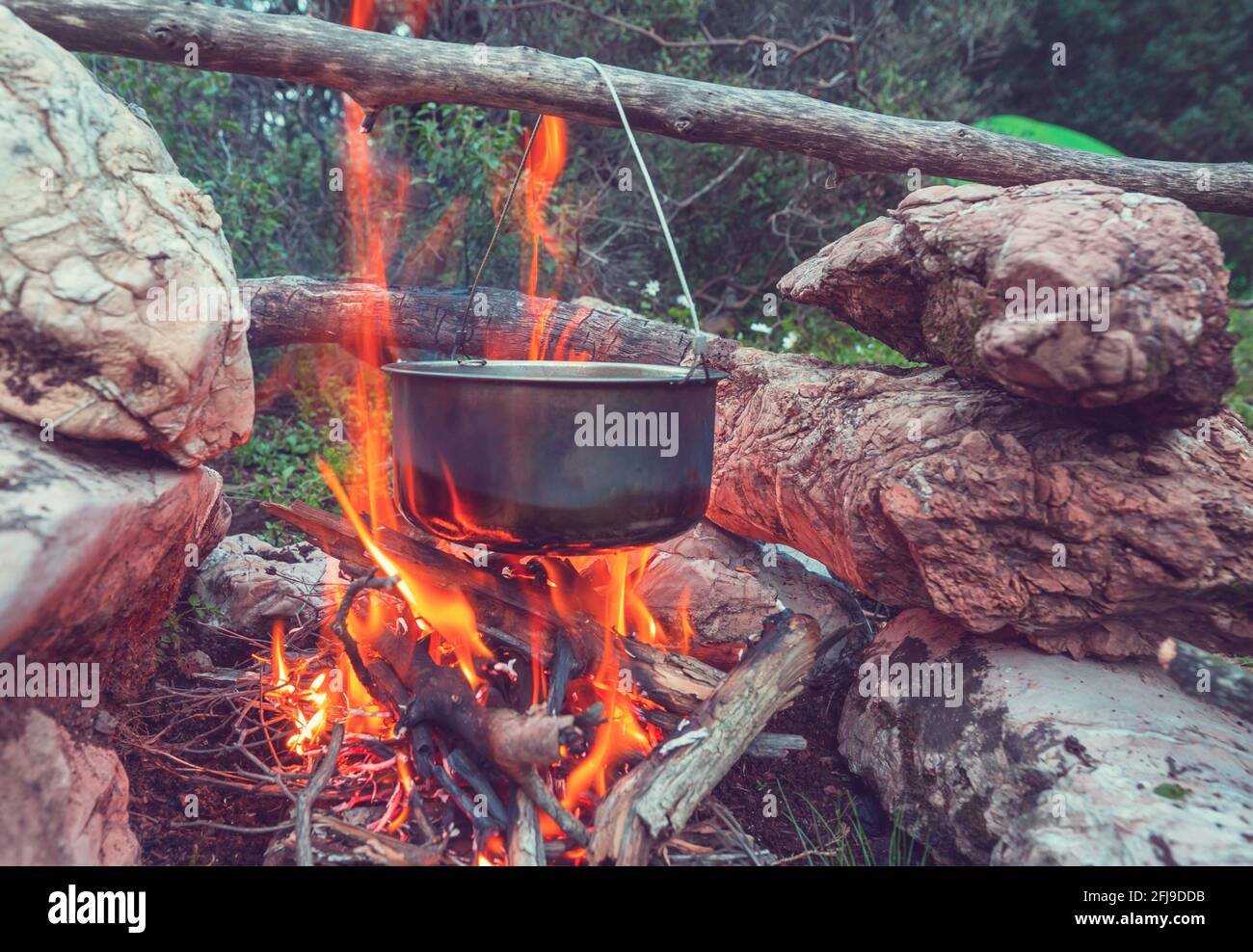 Touristic kettle on fire of burning campfire in camping in the hike ...