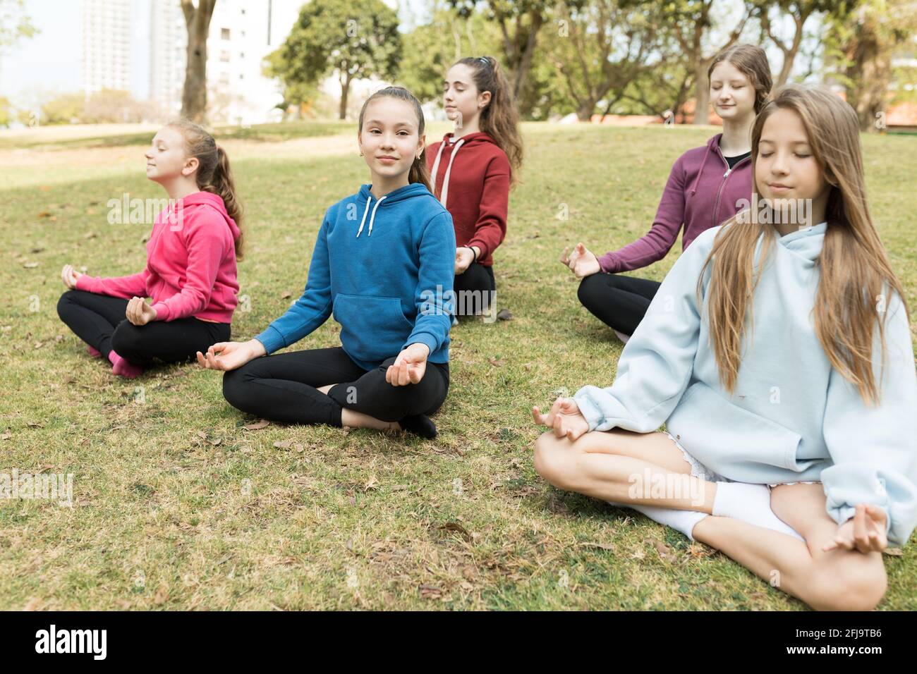 Group of girls bpracticing yoga outside Stock Photo
