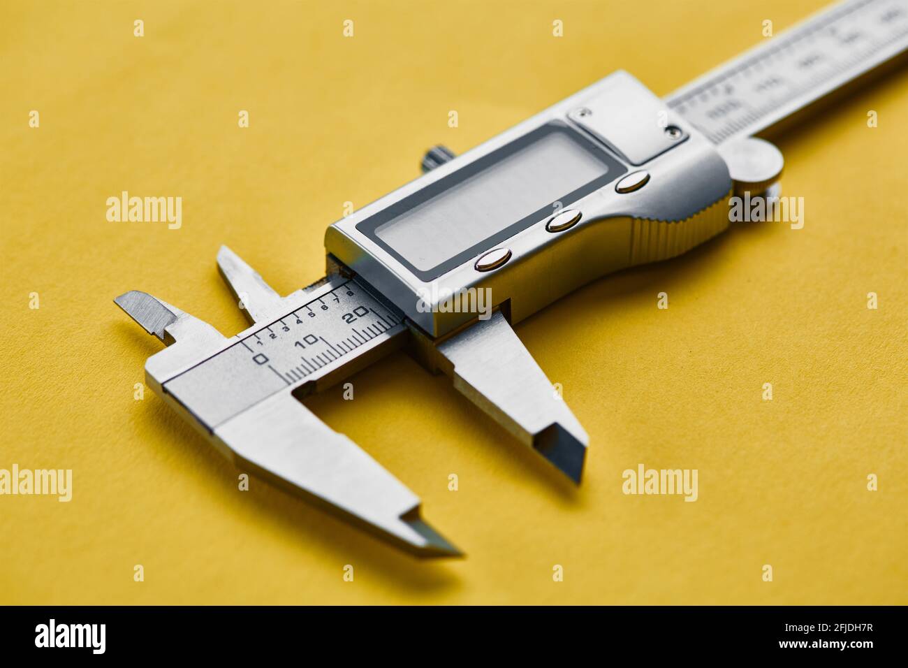 Electronic vernier caliper, yellow background Stock Photo