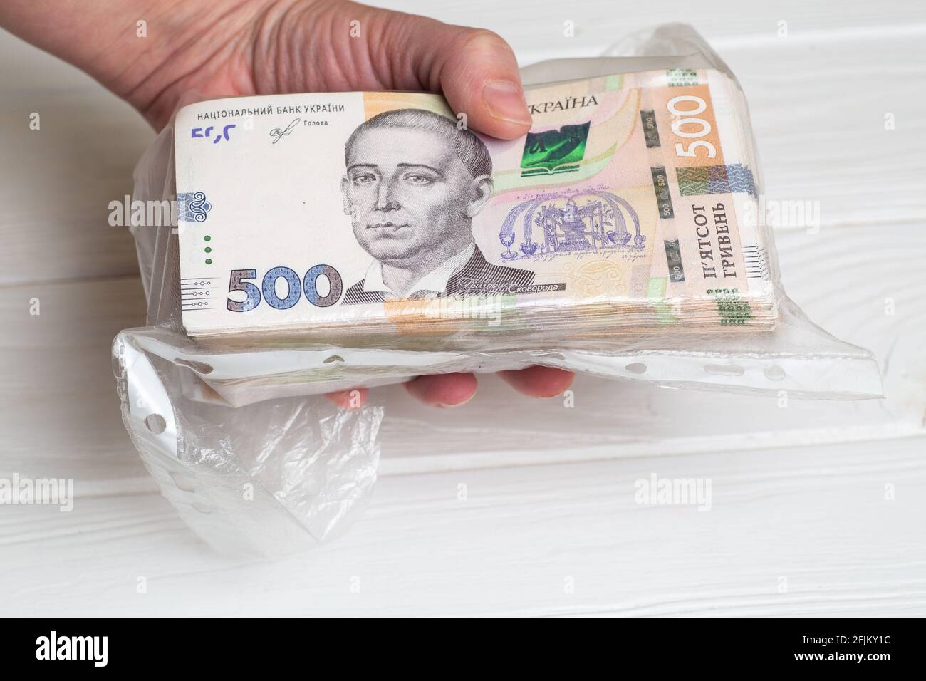 Money of Ukraine. Stack of ukrainian hryvnia banknotes in plastic transparent bag in hands Stock Photo