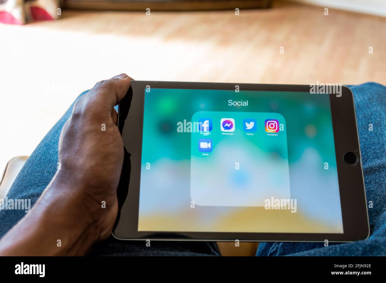 Adult male looking at Social media icons on ipad Stock Photo