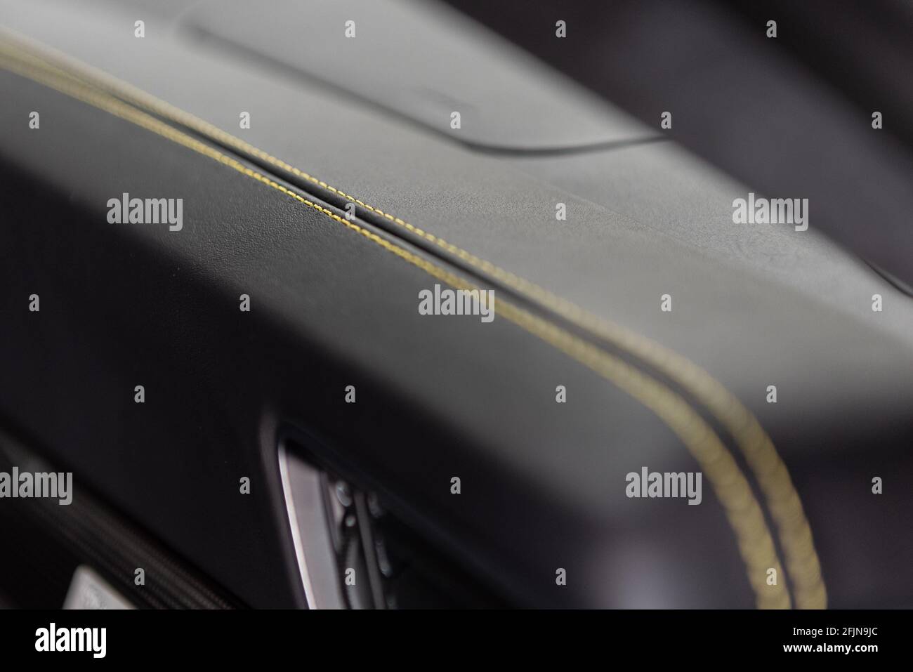 Fine details on this car interior dashboard with yellow stitching on a double row on the seam. Stock Photo