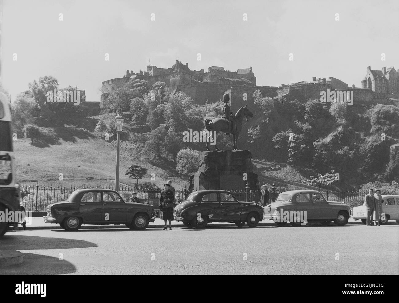 1956, historical, Scotland, Edinburgh, a view of Princes Street, with motor cars of the era parked by the Royal Grey's memorial statue, with the famous castle in the background. Unveiled in 1906, the statue commemorates the Royal Scot Greys who left the city to fight in South Africa in the Boer War, 1899 and in other previous military campiagns. Edinburgh Castle is the Regimental HQ of the Royal Scots Dragoon Guards. Stock Photo