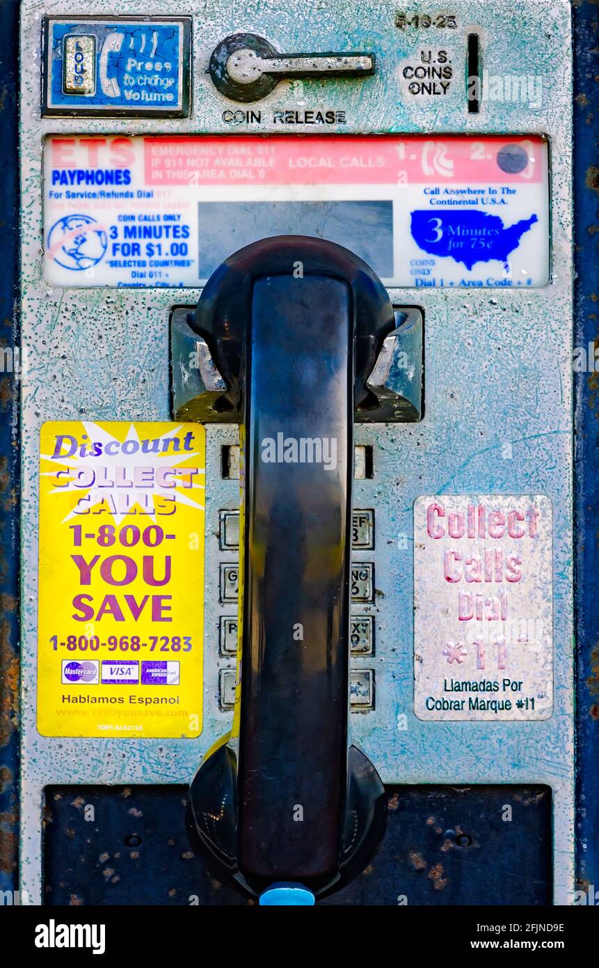 A coin-operated public telephone also called a payphone, hangs on the wall outside the Pascagoula Railroad Depot in Pascagoula, Mississippi. Stock Photo