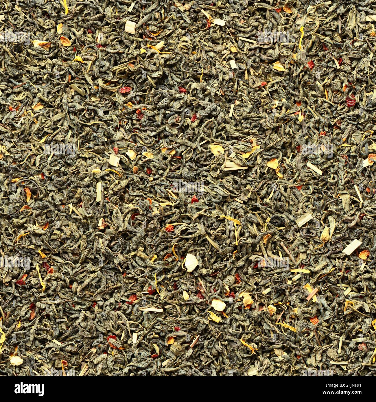 Seamless pattern of green tea leaves with the addition of dry fruits as flavors on a flat surface. Minsk. Belarus. Stock Photo