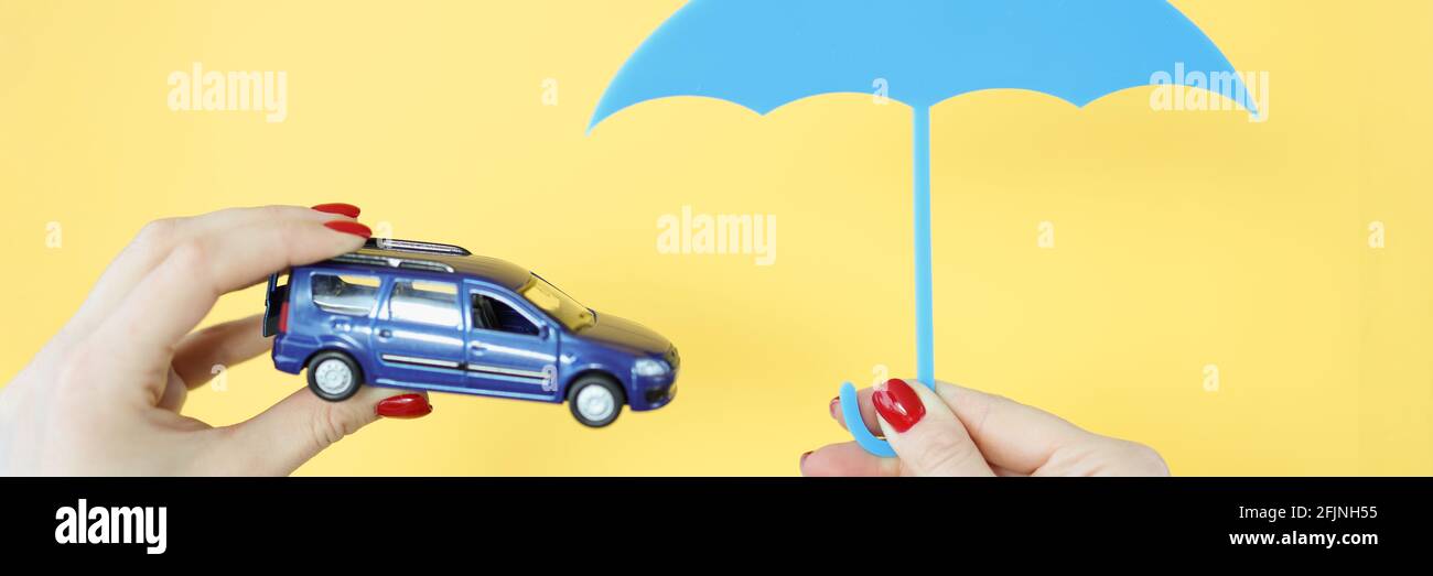 They are holding a car and an umbrella. Stock Photo