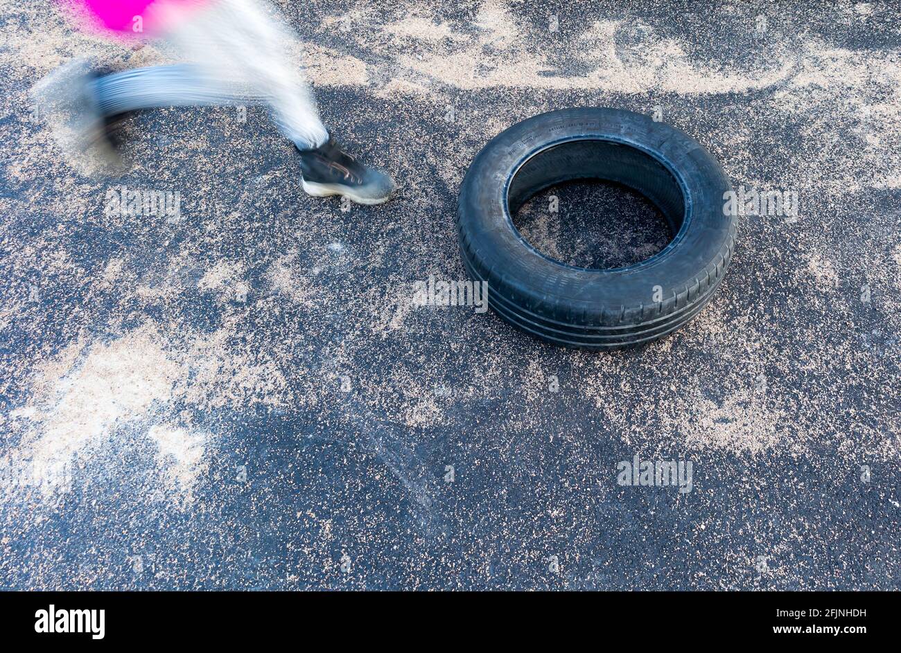 Obstacle race child jumping through tire playing Stock Photo Alamy
